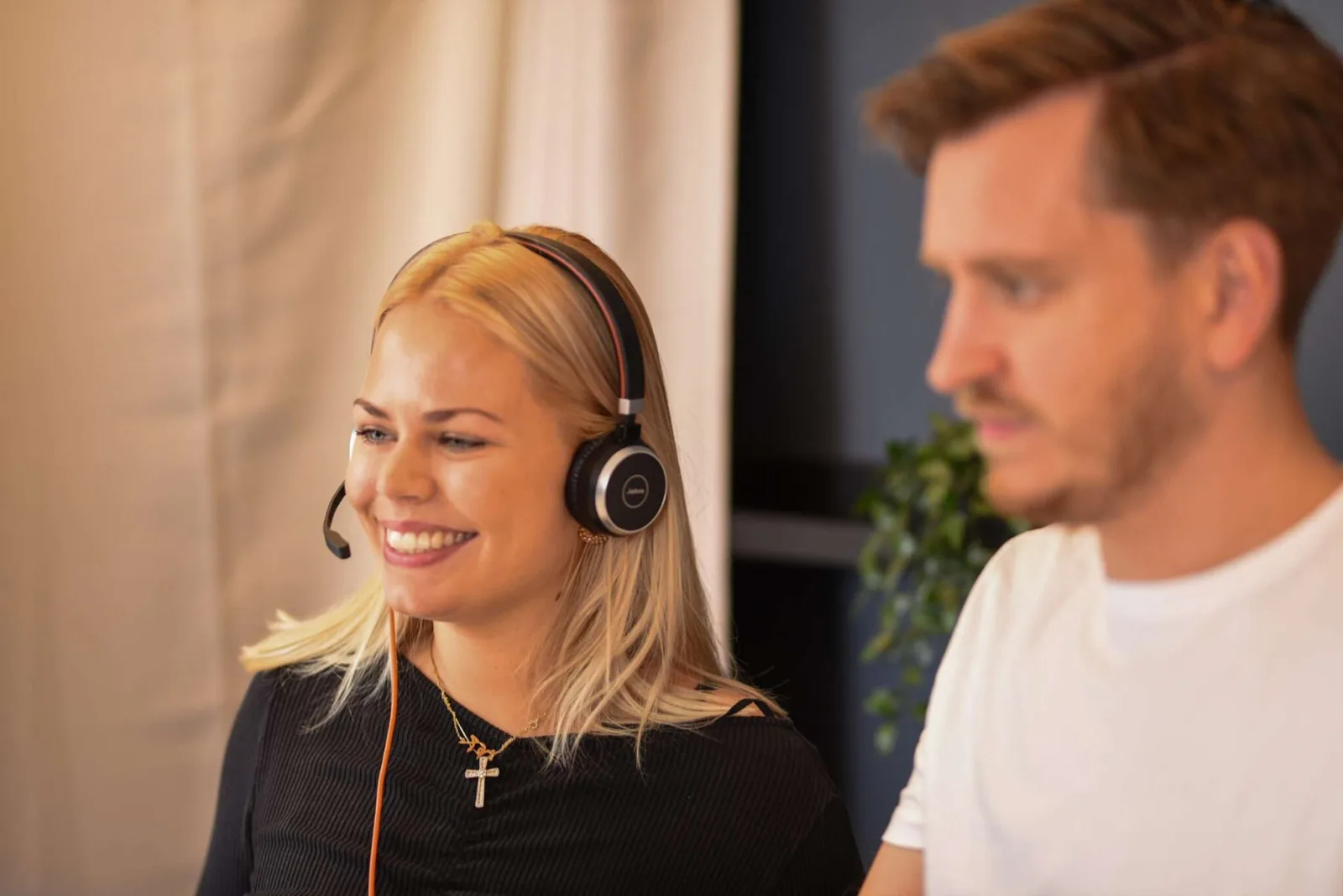 To medarbejdere hos CitizenOne, den forreste med headset på, under en samtale med en kunde.